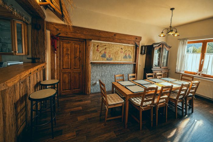Jídelní stůl a průhled k baru s doškovou stříškou
