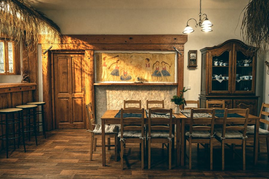 Solid dining table with a folk painting and a sideboard
