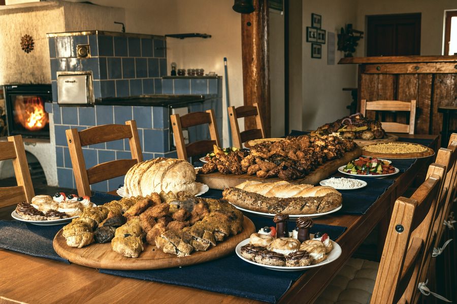 Catering buffet on the dining table by the tiled stove